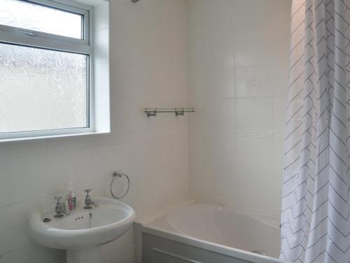 锡豪西斯Seaholme的白色的浴室设有水槽和浴缸。