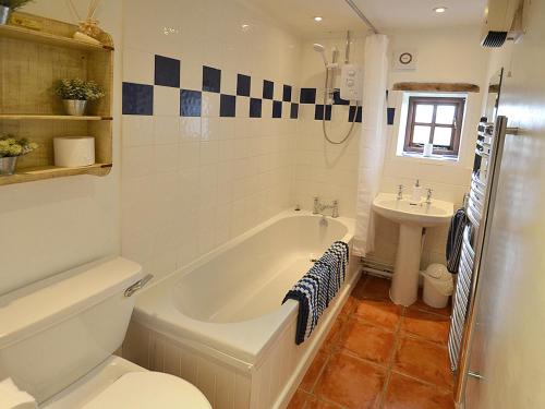 Crowan朗恩谷仓度假屋的带浴缸、卫生间和盥洗盆的浴室