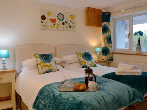 LlansadwrnMarlais View的一间卧室配有两张床,上面放着一个食物盘