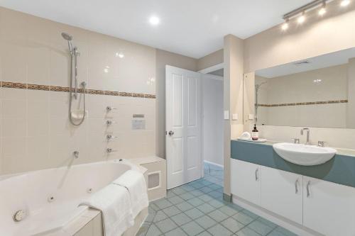 赫斯基森杰维斯湾景色别墅的白色的浴室设有浴缸和水槽。