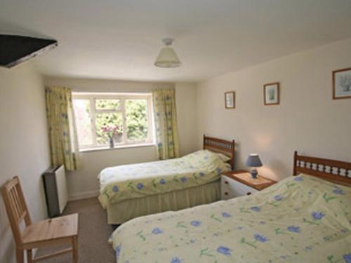 BanwellMaxmills Cottage - E1852的一间卧室设有两张床和窗户。
