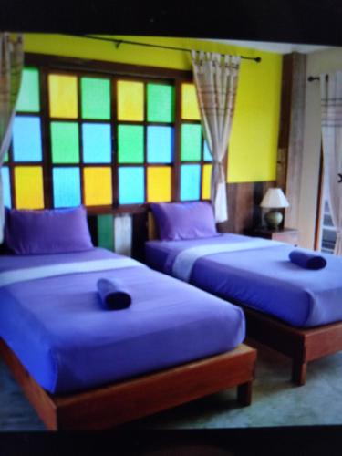 清刊เชียงคานบุรี的带彩色玻璃窗的客房内的两张床