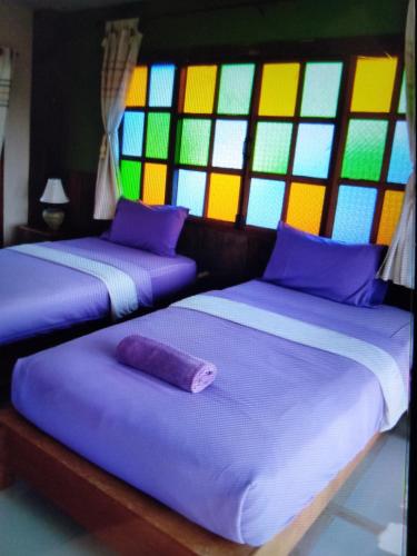 清刊เชียงคานบุรี的带彩色玻璃窗的客房内的两张床