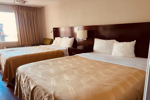 俄克拉何马城Cambridge Inn的酒店客房设有两张床和窗户。