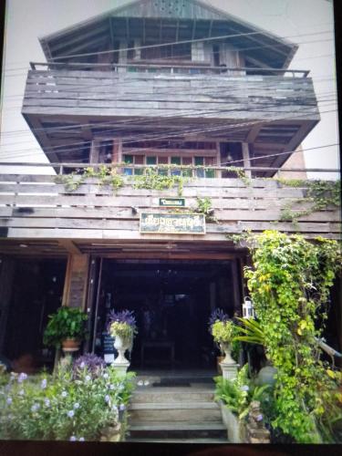 清刊เชียงคานบุรี的一座有盆栽植物的建筑,上面有标志