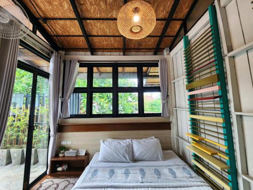 清莱清莱班迈克拉丹旅舍的一间位于小房子的卧室,配有床和窗户