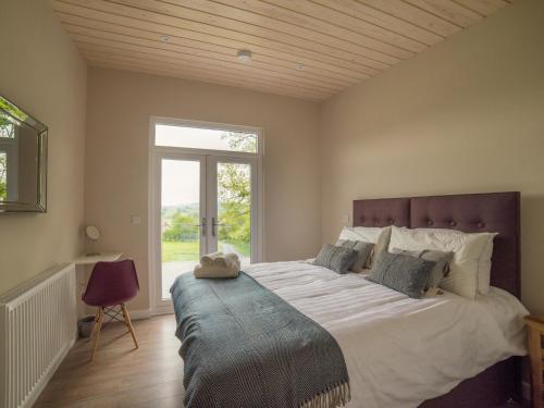 HighgateBarn Owl Lodge-qu7487的一间卧室设有一张大床和大窗户