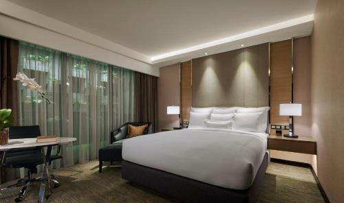 吉隆坡JW万豪酒店的卧室配有一张白色大床和一张书桌