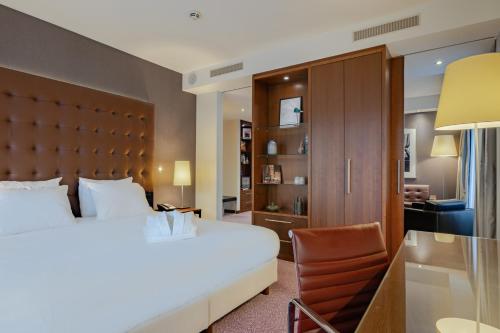 阿姆斯特丹阿姆斯特丹城南皇冠假日酒店的配有一张床和一把椅子的酒店客房