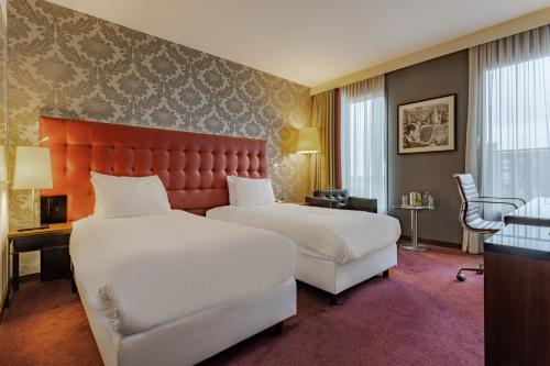 阿姆斯特丹阿姆斯特丹城南皇冠假日酒店的酒店客房设有两张床和红色床头板