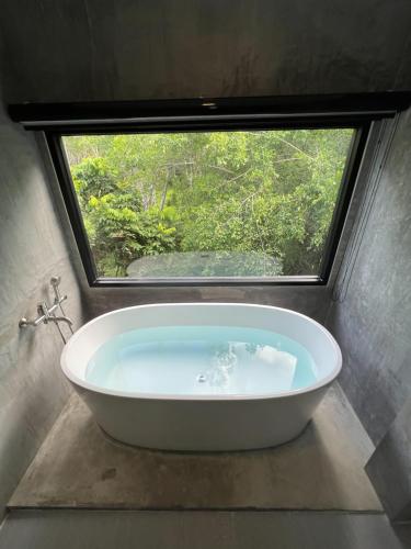 他朗Luancharoen Home Resort Phuket的带浴缸的浴室和窗户
