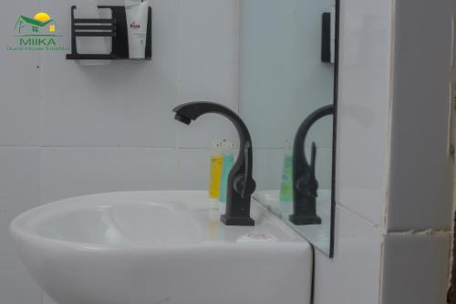 恩德培Miika Guest House的浴室内带两个水龙头的盥洗盆