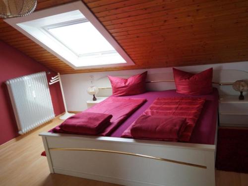 策尔阿姆哈尔梅尔斯巴赫Haus Irmgard的一间卧室配有一张带红色床单的床和天窗。