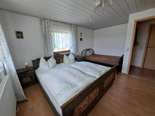 诺伊舍瑙Bauernhof Madlhof的一间卧室设有一张大床和一个窗户。