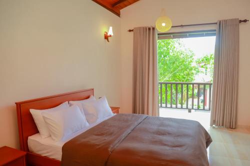 希克杜沃IBSON Villa - 02 Hikkaduwa with 4 Bedrooms & Salt Water Swimming Pool的一间卧室设有一张床和一个大窗户