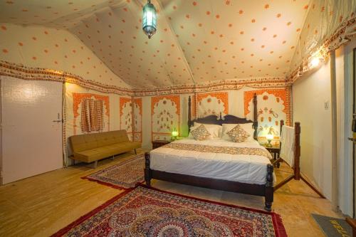 山姆Hilton Jaisalmer Desert camp的一间卧室配有一张床和一张沙发