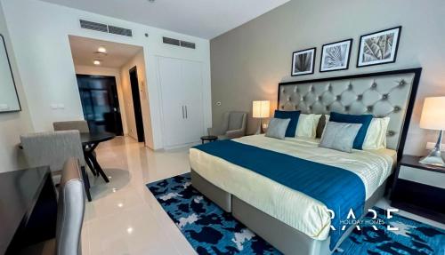迪拜Rare Holiday Homes - Spacious apartment - Near Expo City - Dubai South - R410的一间卧室配有一张大床和一张书桌