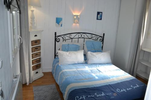 Esblymaison atypique cosy Disneyland Paris/la vallée village/parking的一间卧室配有一张带蓝色床单和白色枕头的床。