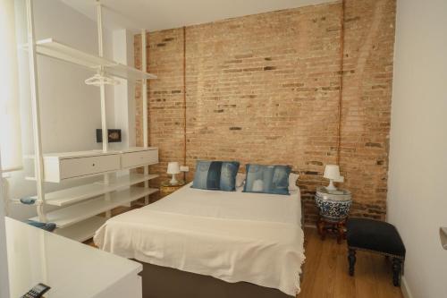 略夫雷加特河畔奥斯皮塔莱特Villa Conde的一间卧室设有一张床和砖墙