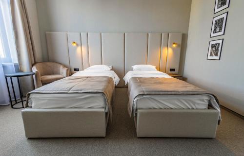 基希讷乌摄政酒店的小型客房配有两张床铺和椅子
