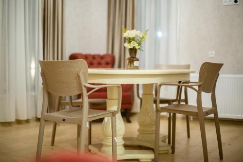 库塔伊西Moedani-Very Center Apartments in Kutaisi的餐桌、椅子和花瓶