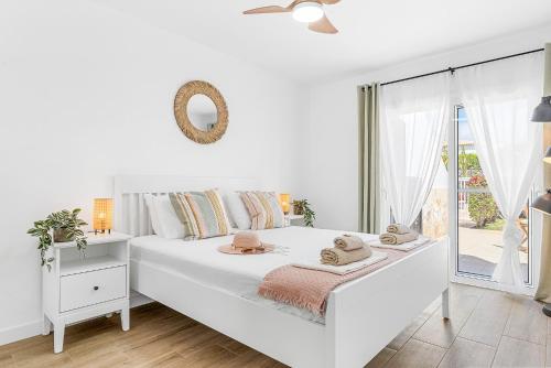 圣米格尔德阿沃纳Holiday Garden House in Golf del Sur的白色的卧室设有白色的床和窗户。