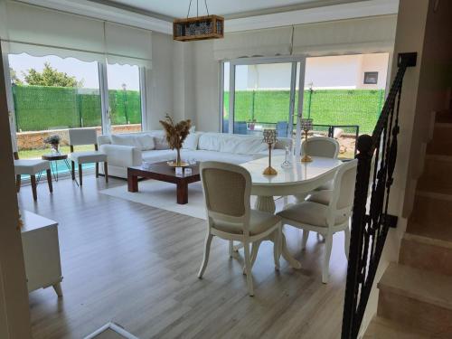 卡特佩Villa Mila的客厅配有白色的桌子和椅子