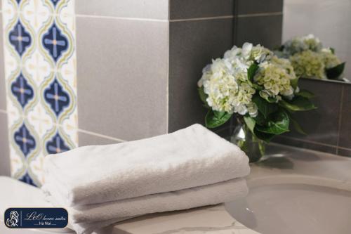 河内Home suites -Natural light -Projector -Spacious - 2BR incenter的浴室水槽上堆满鲜花的毛巾