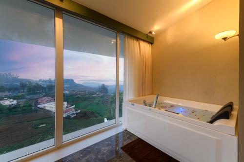 乌提Clouds Nest By Aanvis Inn的客房设有浴缸和大窗户。