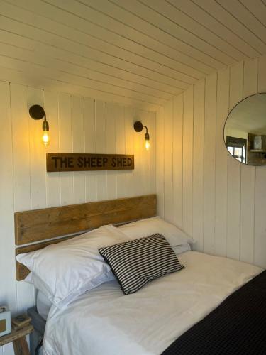 基德灵顿Shepherds Huts的墙上有标牌的房间的一张床位