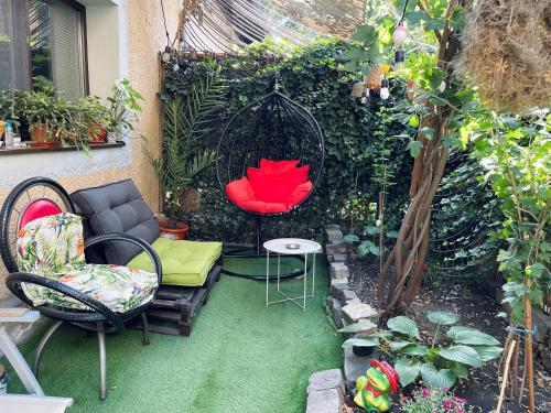 布加勒斯特City Garden Apartments的一个带椅子和秋千的小花园