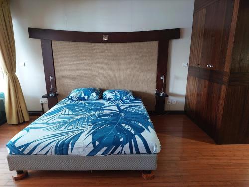 阿鲁埃Toupidek-sur-la-Plage的一间卧室配有一张带蓝色和白色棉被的床