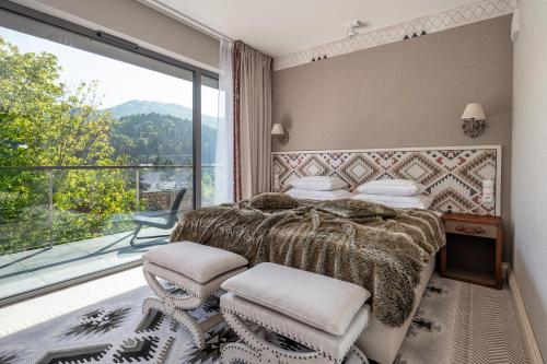 什切尔克Aries Hotel & SPA Szczyrk的一间卧室设有一张床和一个大窗户