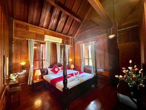 琅勃拉邦Lakhang Thong Hotel的一间卧室配有一张带红色枕头的床