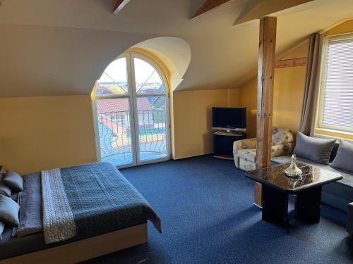 布拉格阿里安酒店的一间卧室配有一张床、一张沙发和一张桌子