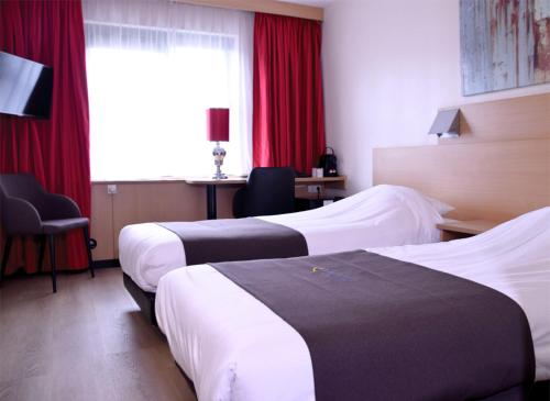 莱顿莱顿福尔斯霍滕巴斯蒂欧酒店的配有红色窗帘的酒店客房的两张床