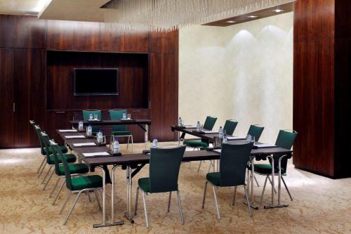 阿布扎比Southern Sun Abu Dhabi的一间会议室,配有长桌子和绿色椅子