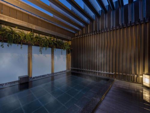 东京宜必思尚品东京东银座酒店的一座室内泳池,里面种有植物