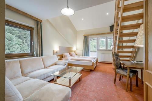 奥伯古格尔Smarthotel Bergresidenz - Adults only的带沙发和螺旋楼梯的客厅