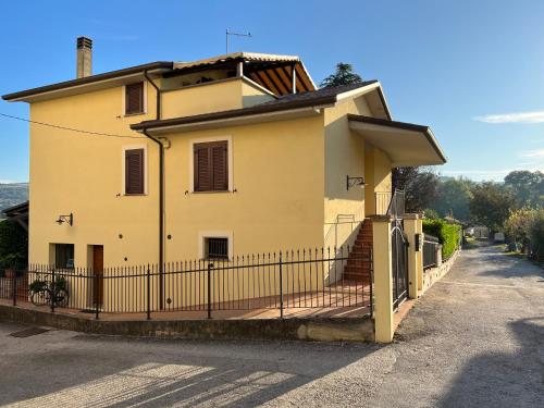 PetrignanoAssisi, la Noce的一座大型黄色房屋,设有黑色的围栏