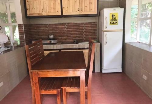 VictoriaRelova’s Orchard Place的厨房配有木桌和白色冰箱。