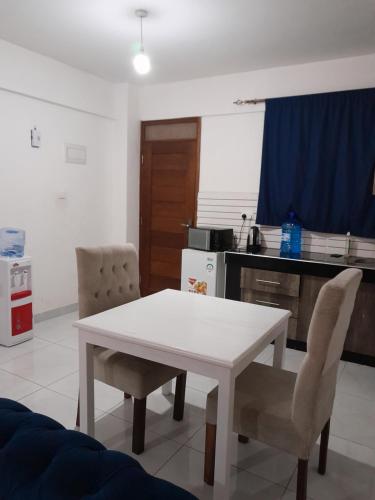 蒙巴萨MEDZAM HOME PROPERTIES COSY One bedroom的厨房配有白色的桌子和两把椅子