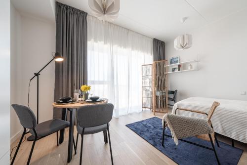 塔林Unique Kalaranna District Apartment by the Sea的卧室配有一张床和一张桌子及椅子