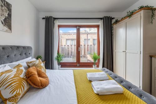 伦敦The Waterloo Apartment - Large Private Patio & Air Conditioning的一间卧室配有一张带黄色毯子的大床