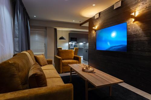 罗瓦涅米Royal Roi Apartments的客厅配有沙发和墙上的电视