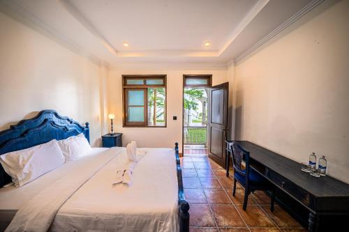 沙努尔Pitaloka Hotel Sanur By DeWizZ Management的一间卧室配有一张大床和蓝色床头板