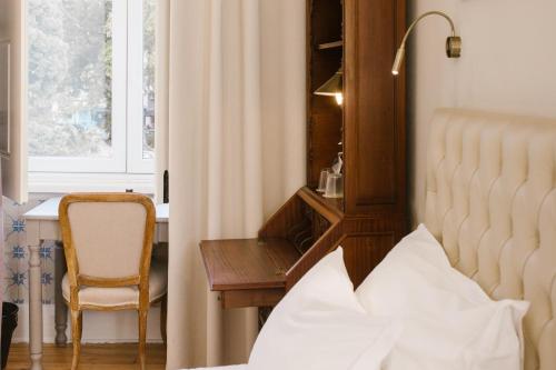 里斯本Alegria A Lisbon Boutique Hotel的卧室配有床、椅子和窗户。