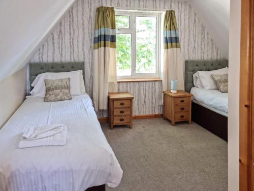 甘尼斯莱克Dartmoor 3的一间卧室设有两张床和窗户。