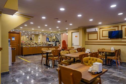 安卡拉Hamit Hotel Kizilay的一间带木桌椅的餐厅和一间厨房