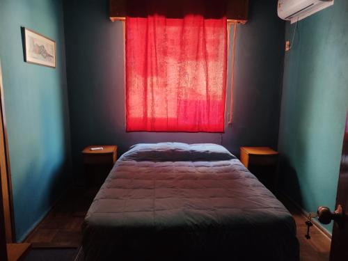 蒙得维的亚Patio Urbano Suites & beds的一间卧室设有一张床和一个红色的窗户